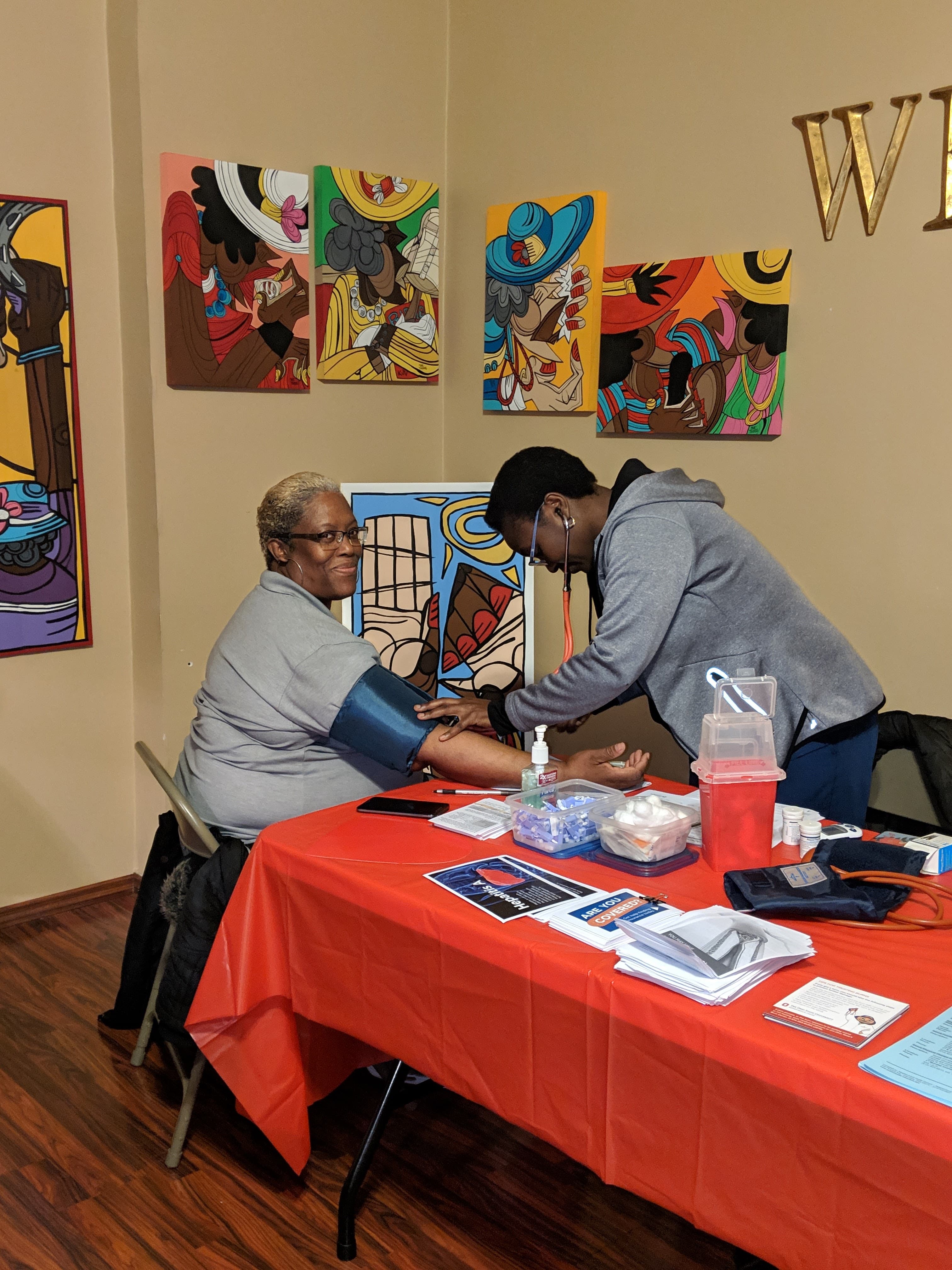 Community health programming event with participants gathered for health education